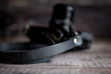 Load image into Gallery viewer, Close-up of crackle finish texture on antique black leather camera strap