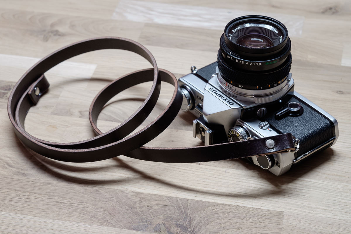 Short leather neck strap attached to compact camera perfect for travel photography