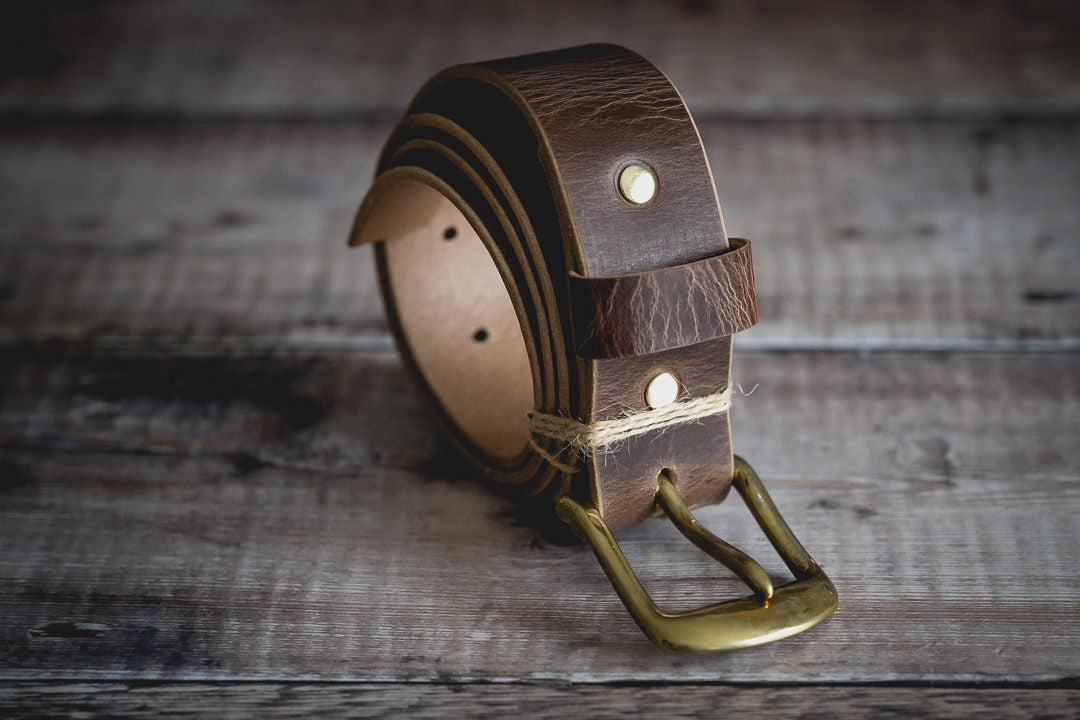 Close-up of hand-stitched keeper on antique brown veg tan leather belt