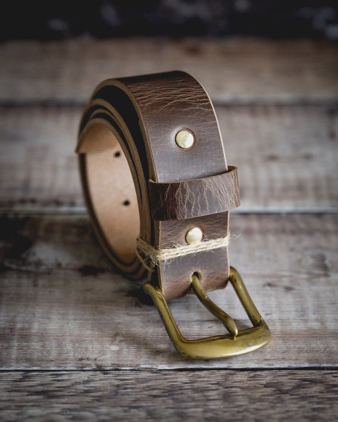Premium veg tan leather belt showing antique brown finish and natural grain