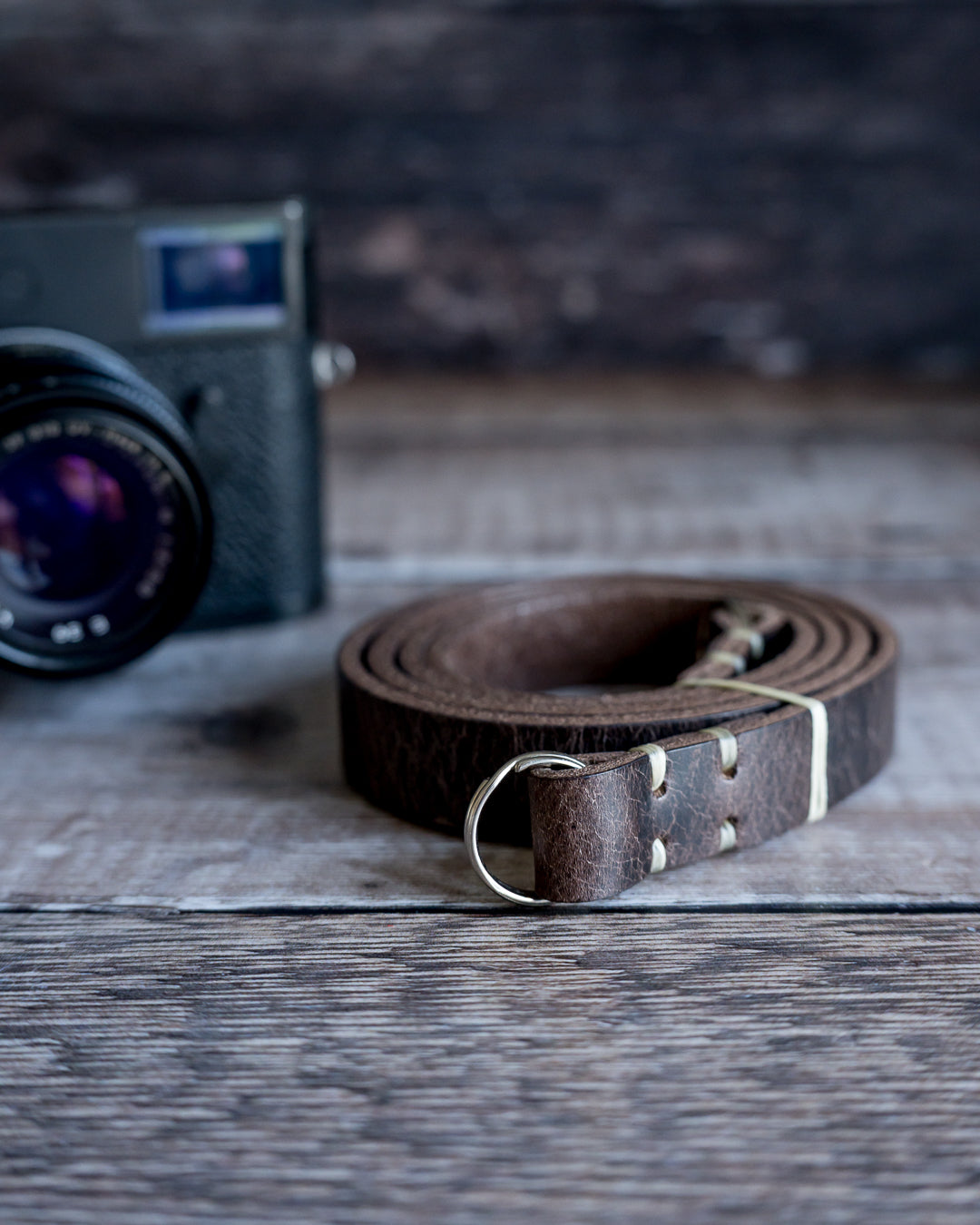 Premium veg tan leather camera strap showing natural waxed polyester stitching