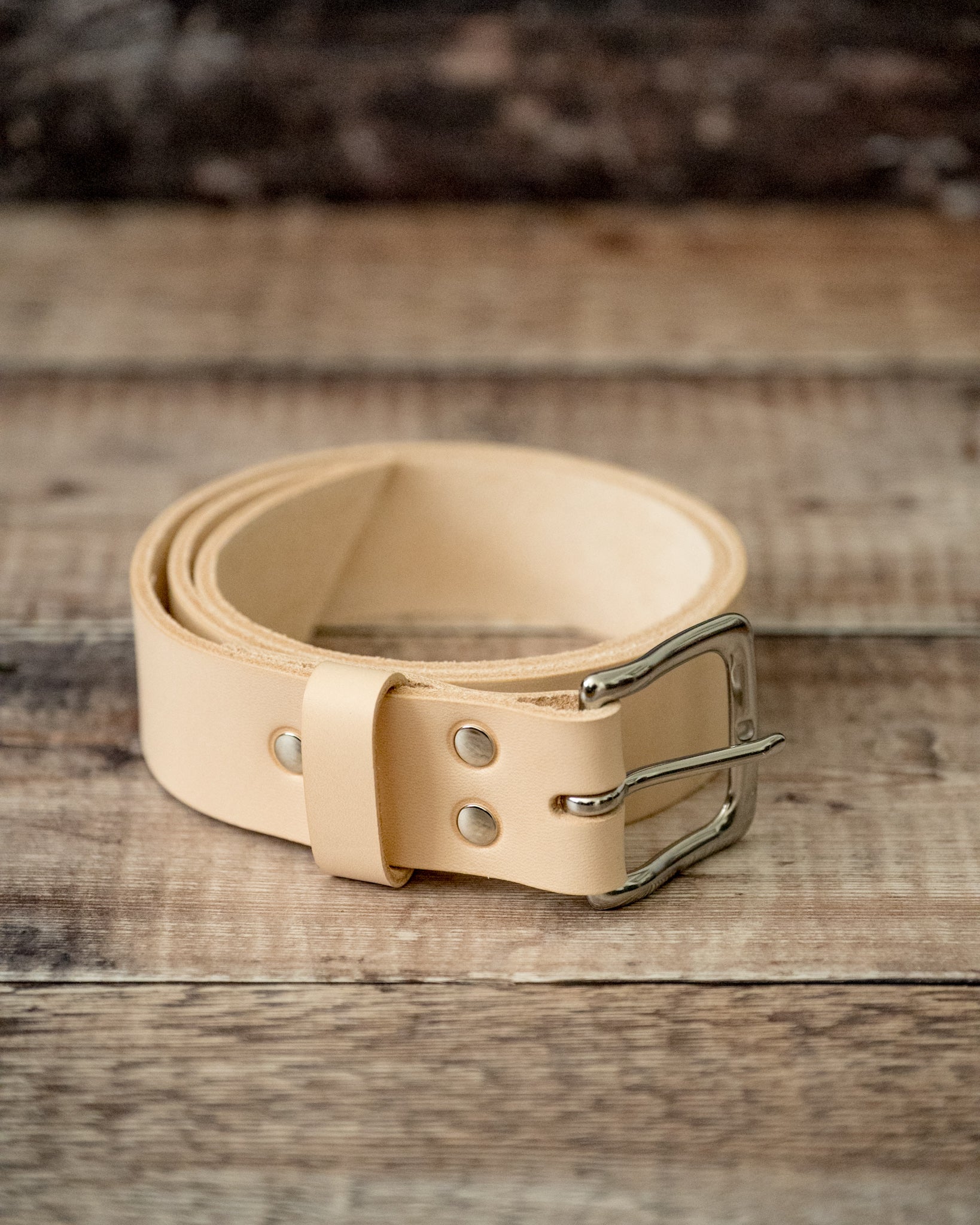 Close-up of hand-stitched keeper on natural veg tan leather belt