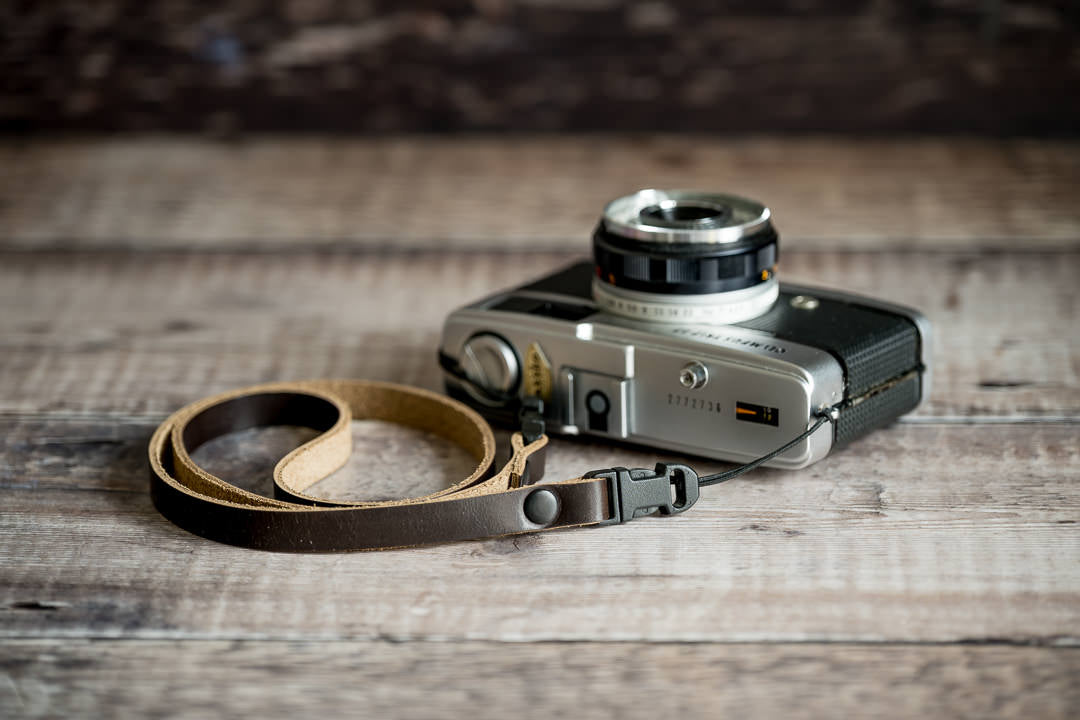 Close-up of quick release connector on slim 10mm leather camera strap