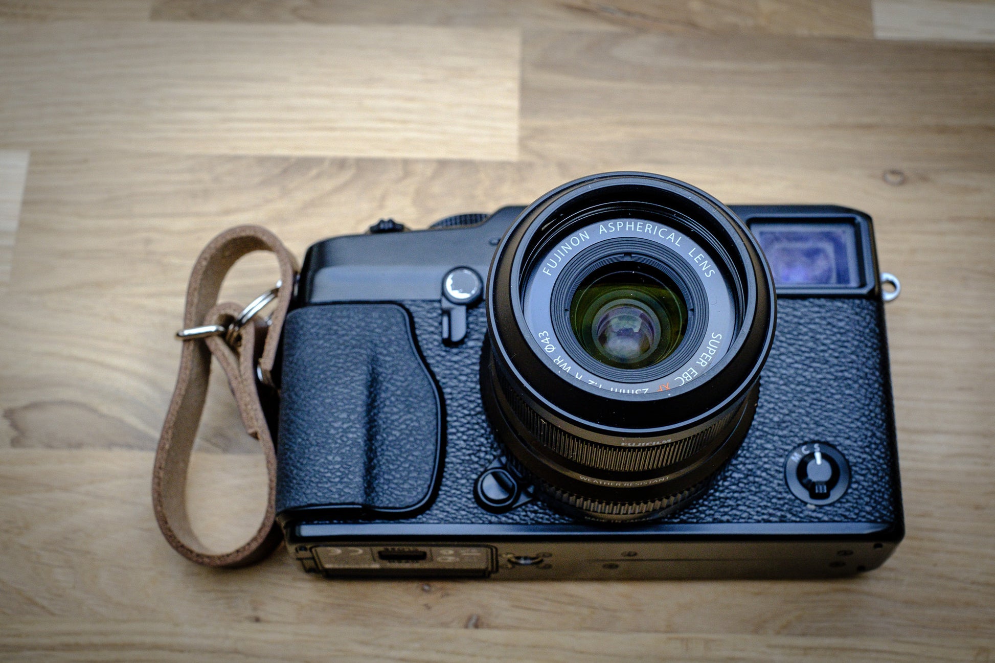 Leather finger strap attached to mirrorless camera for street photography